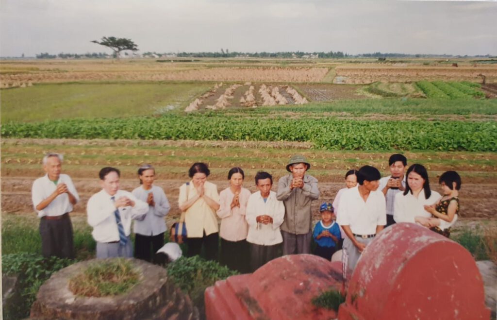 visiting family graves scattered across farm lands in North Vietnam